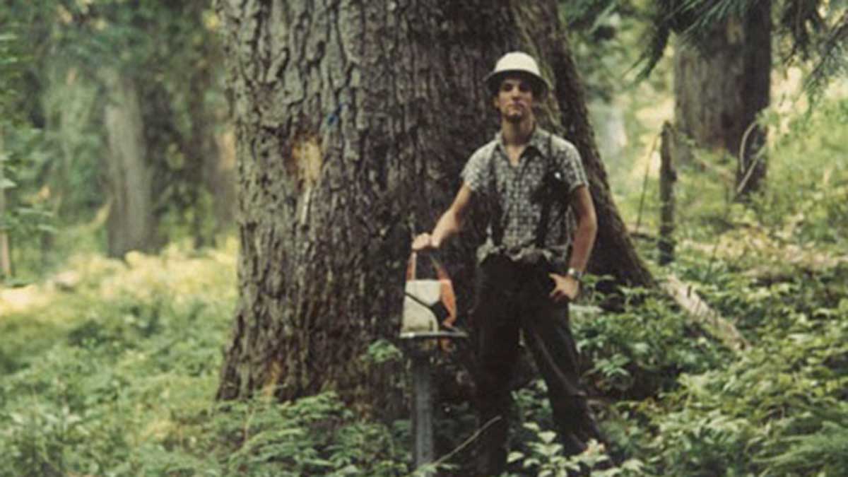 Tom Mueller holding a chainsaw in the forest
