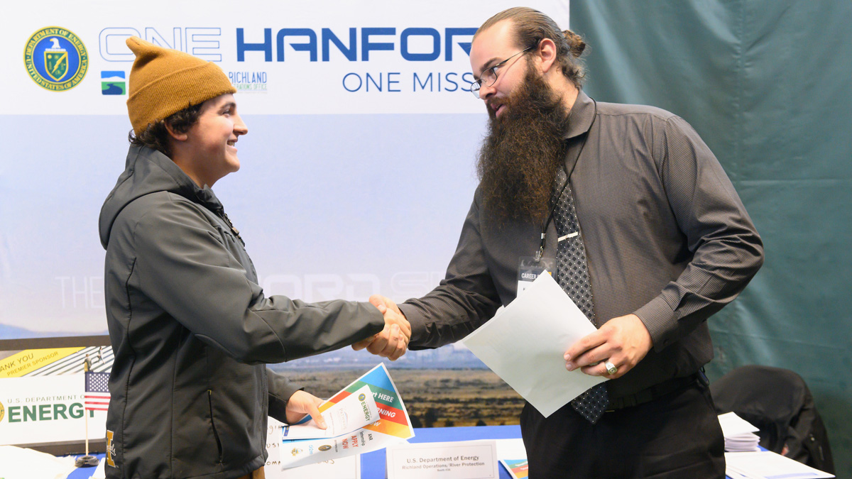 A student shakes hands with an employer at the Career Fair.