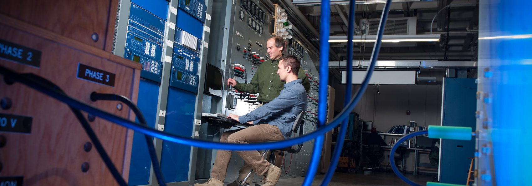 Brian Johnson and Mike West work in the electrical engineering lab to develop a system for measuring power generator parameters with support from SEL.