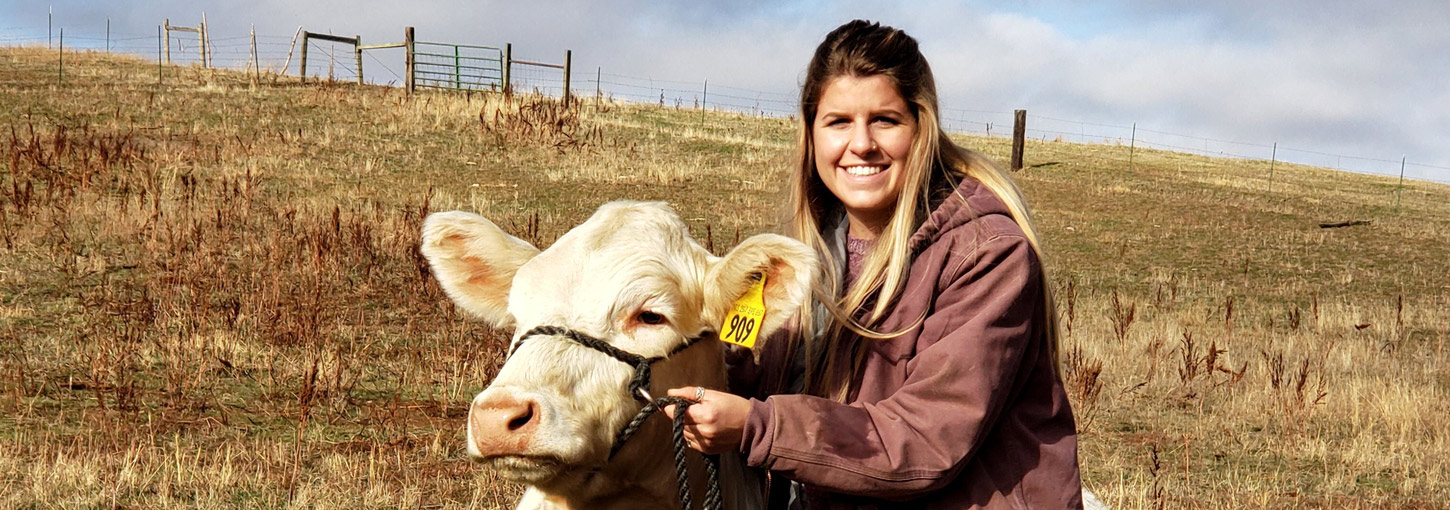 Student Chanelle Brusseau with a cow.