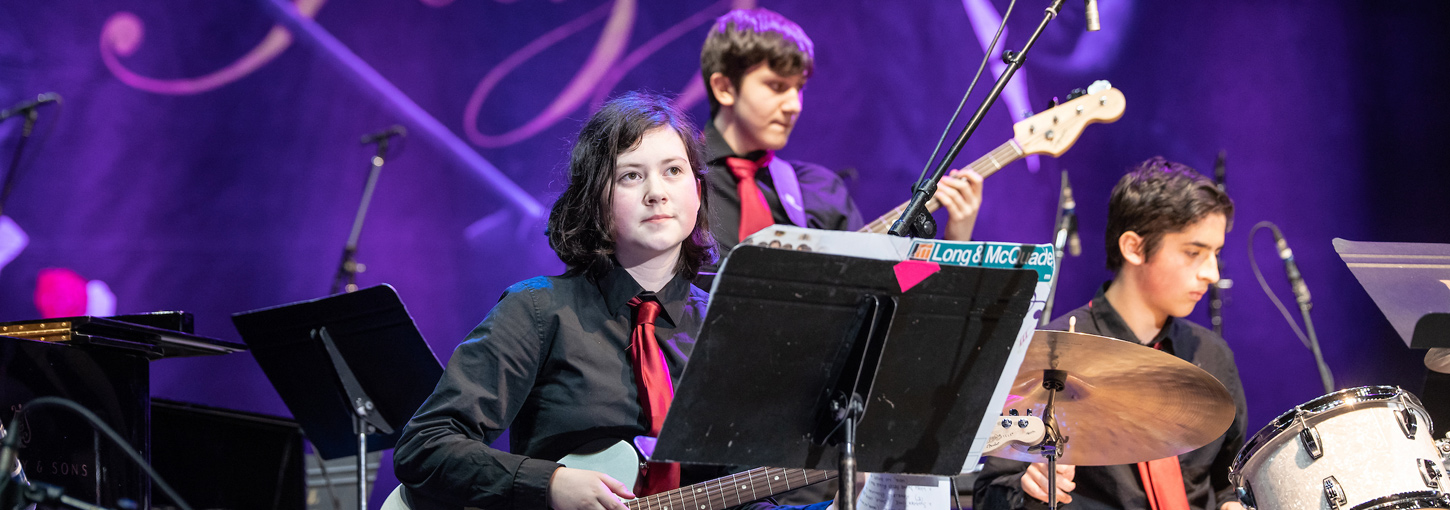 Student musicians with their instruments on stage at the Lionel Hampton Jazz Festival.