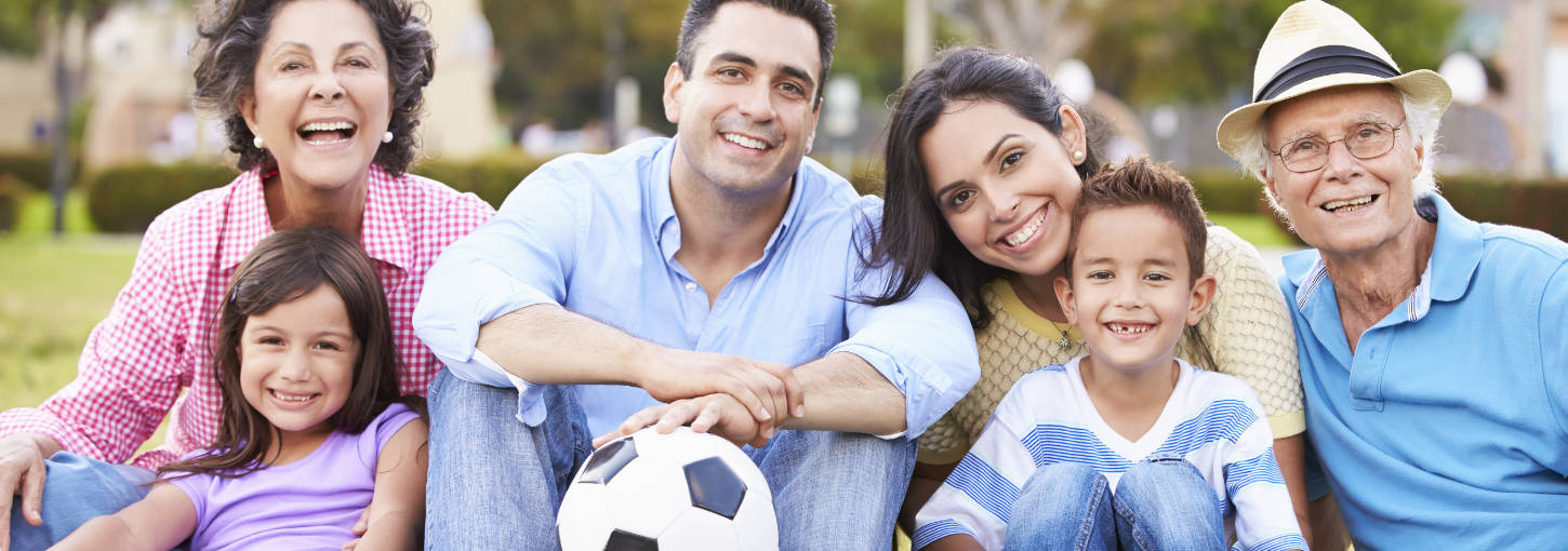 6 members of a multigenerational family pose for a picture. One of the subjects holds a soccer ball.