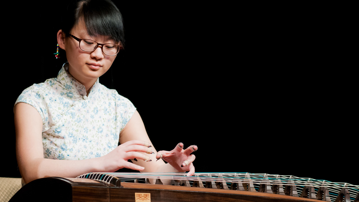 placeholder A woman plays an instrument similar to a harpsichord.
