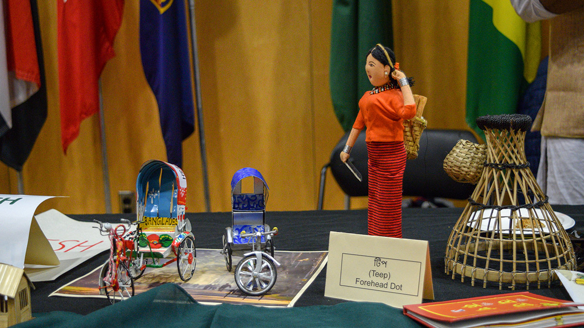 Small replicas of cycle rickshaws, as well as a figurine dressed in traditional Bangladeshi clothing and wearing a forehead dot (or “Teep” in Bengali). Also featured is the flag of Bangladesh, as well as a small replica of a woven basket used to fish with