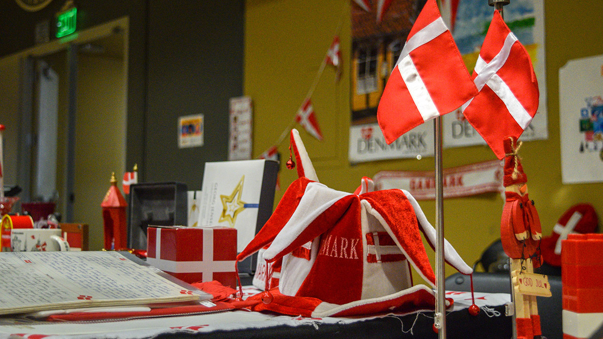 Included is a stand with the Danish flag, a decorative hat worn to sporting events, Legos, a Christmas figurine, as well as several posters of Denmark. 