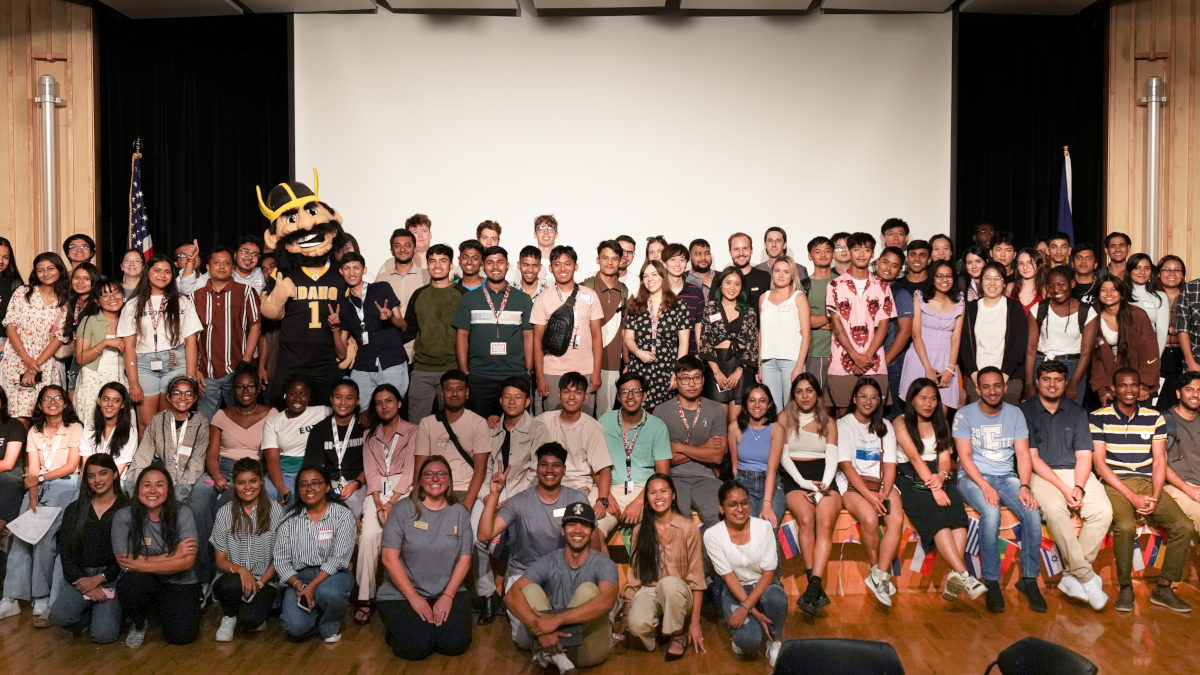 Dozens of people smile and pose for a group photo with an appearance by mascot Joe Vandal.