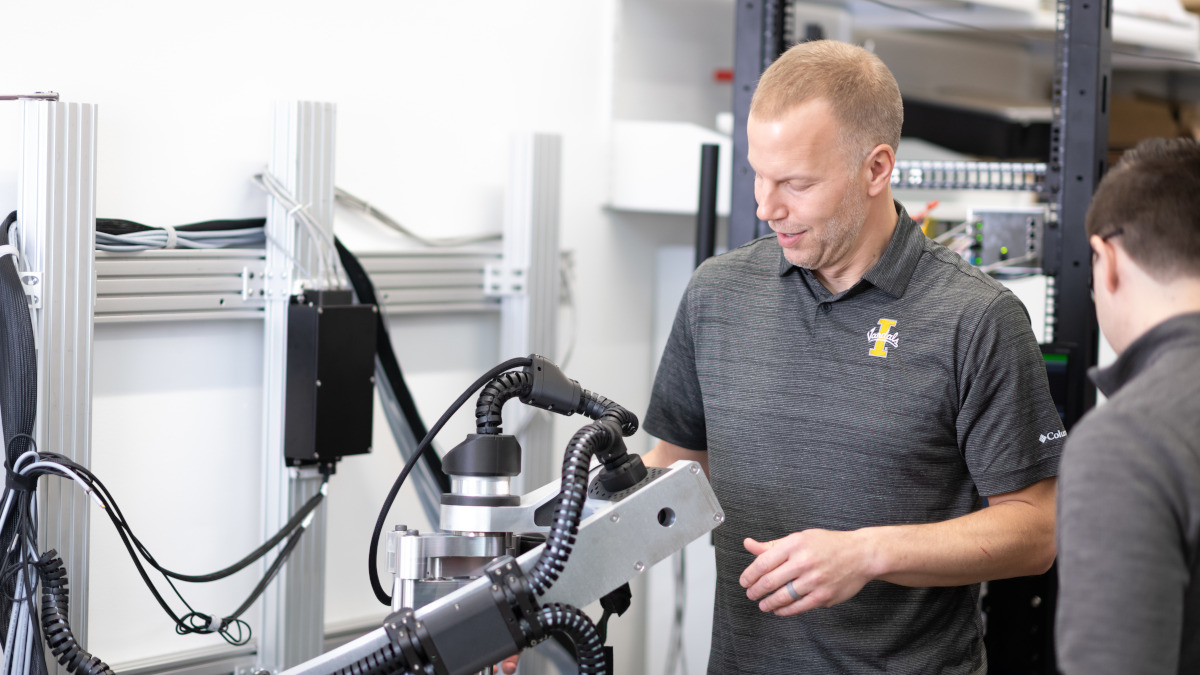 A member of Vandal faculty and staff interacts with complex machinery.
