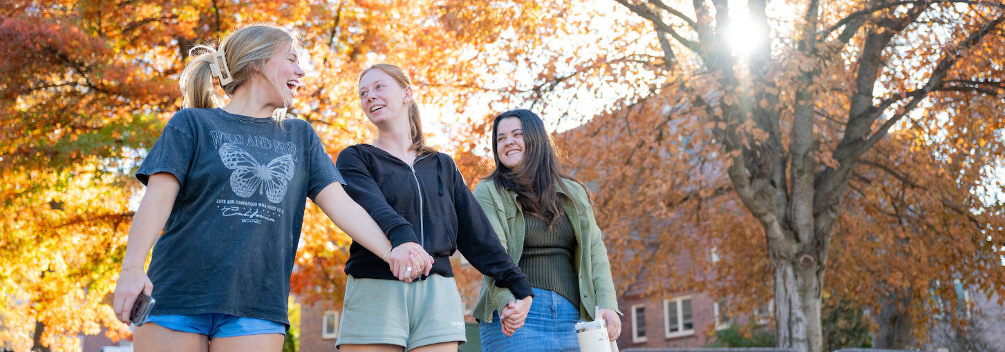 college essay advisors duke A group of students walk hand in hand on campus.