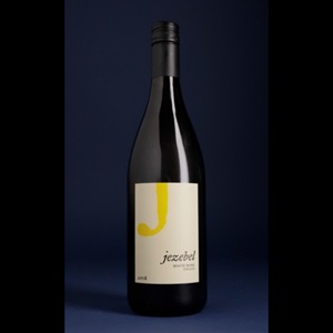 A sealed bottle of Jezebel White Wine 2022 against a dark background.