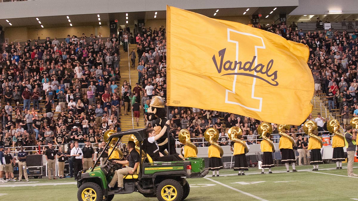 A tractor with Joe Vandal and a giant U of I flag drive through the Kibbie Dome