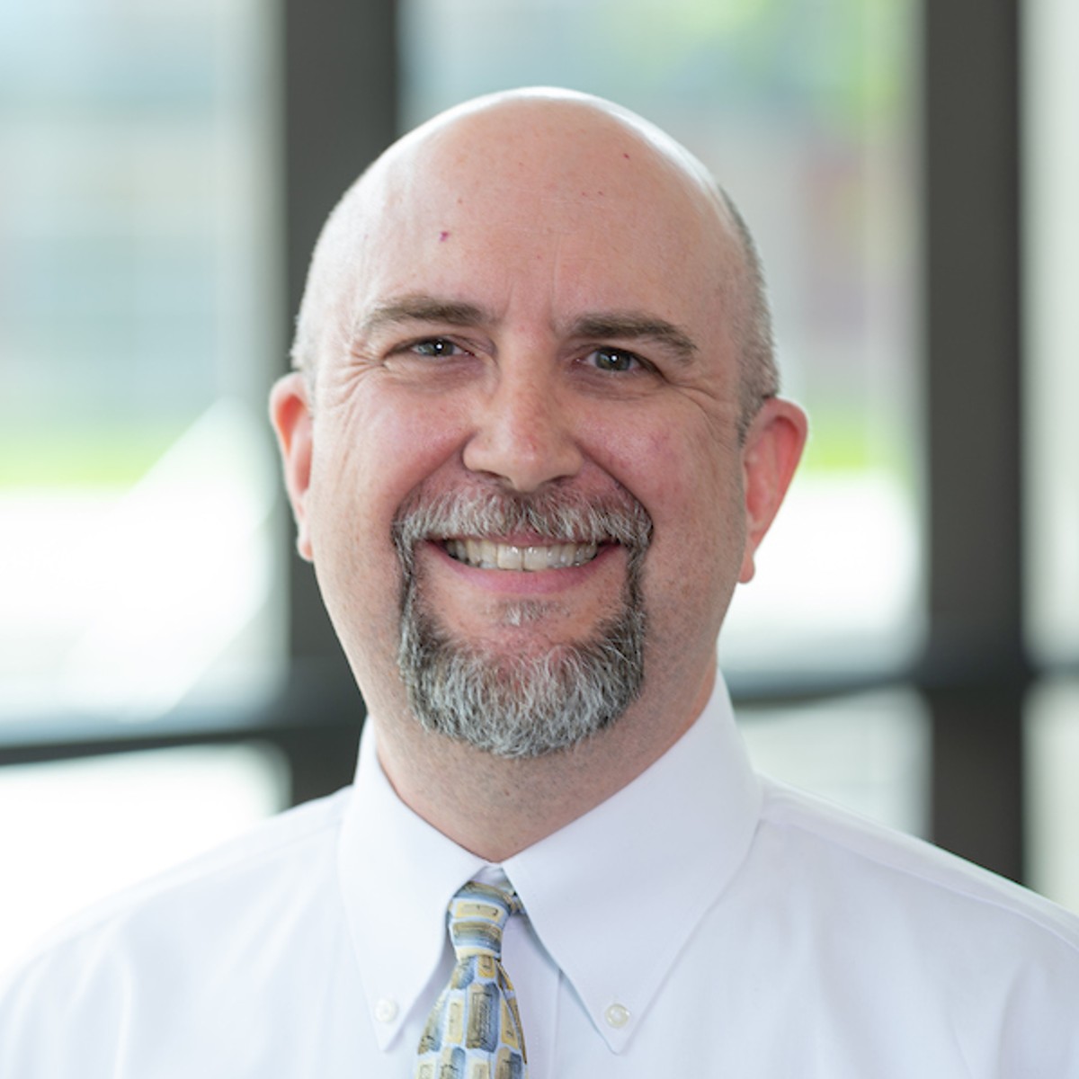 David Jackson smiles in a building filled with natural light