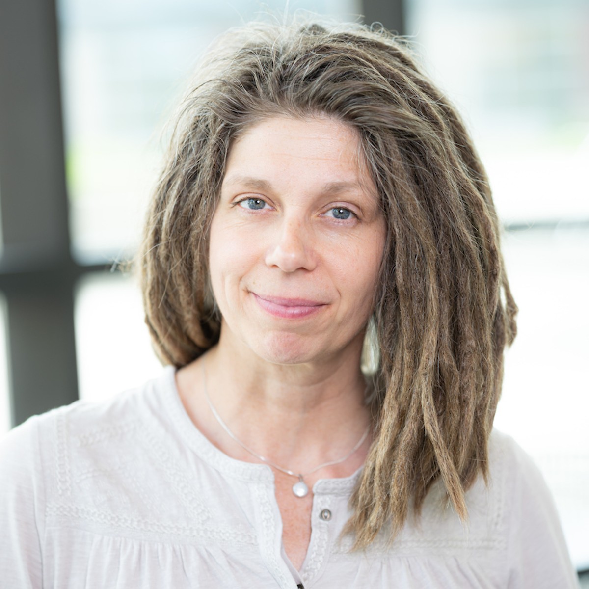 Joy Bauer smiles in a building filled with natural light