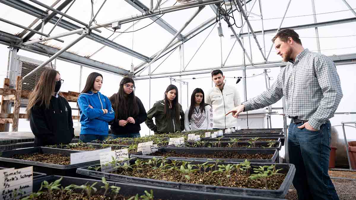 A group of people in a greenhouse.