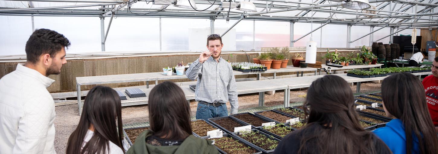 A group of people in a greenhouse.