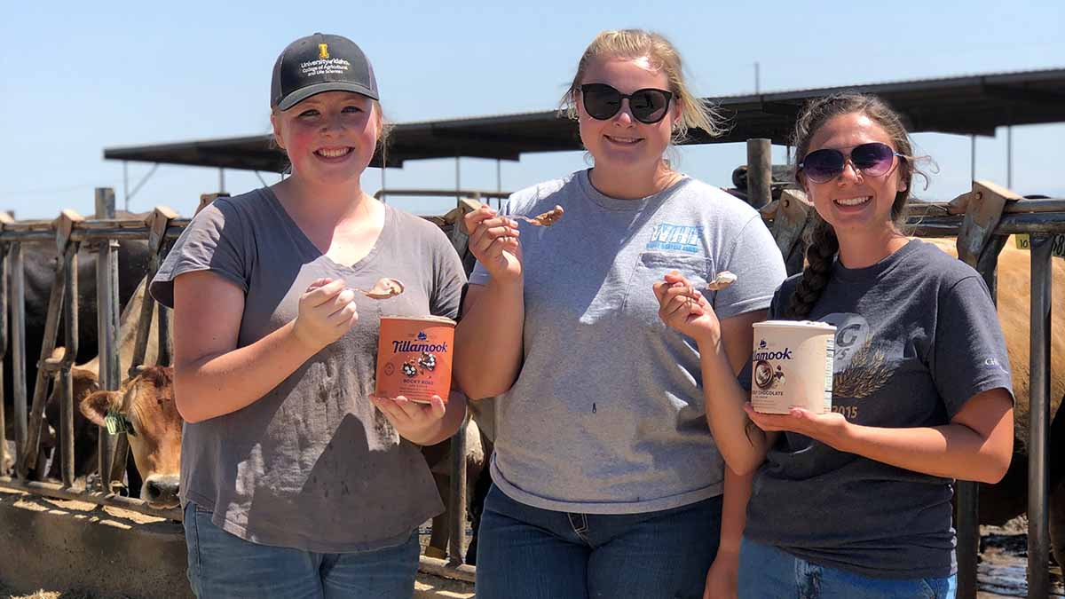 Three women holding ice cream at a dairy farm