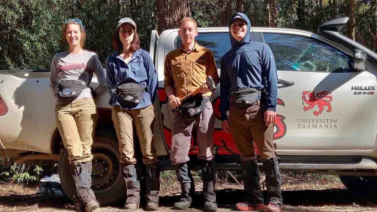 A group leaning against a pickup truck in Tasmania.