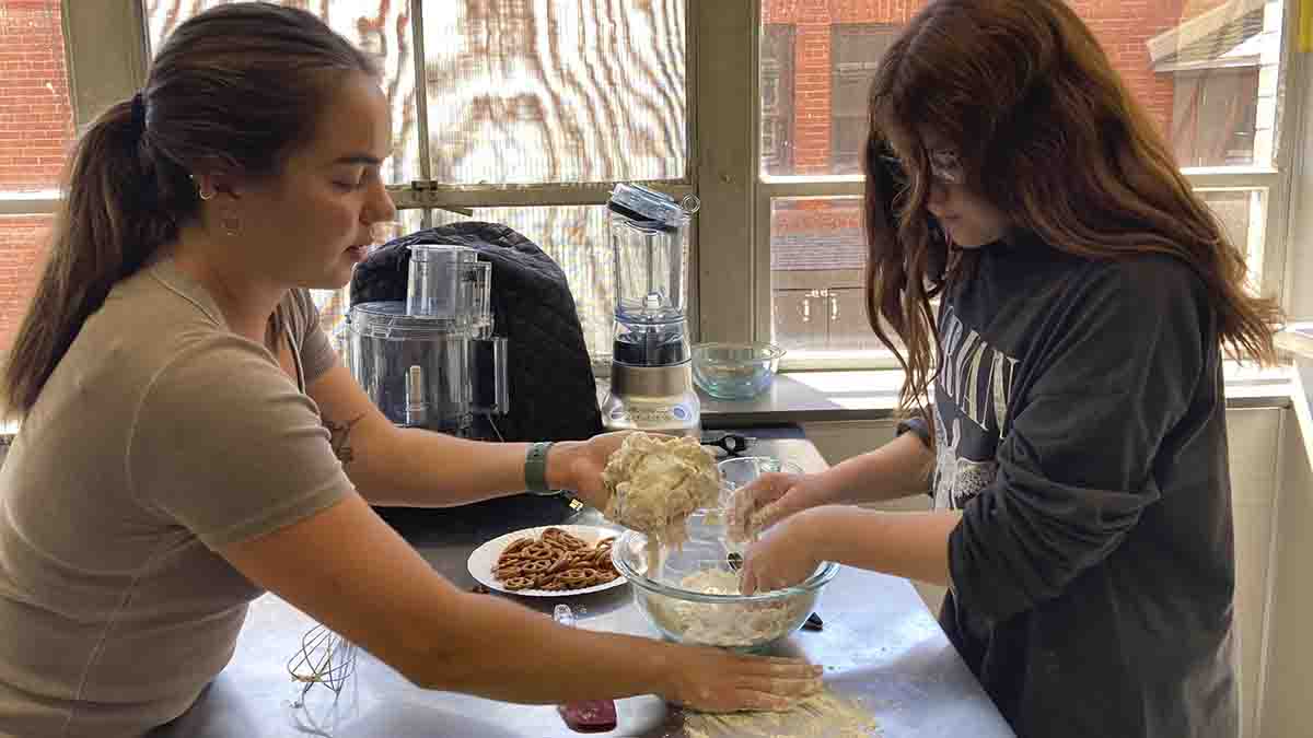 A teacher and student mixing ingredients