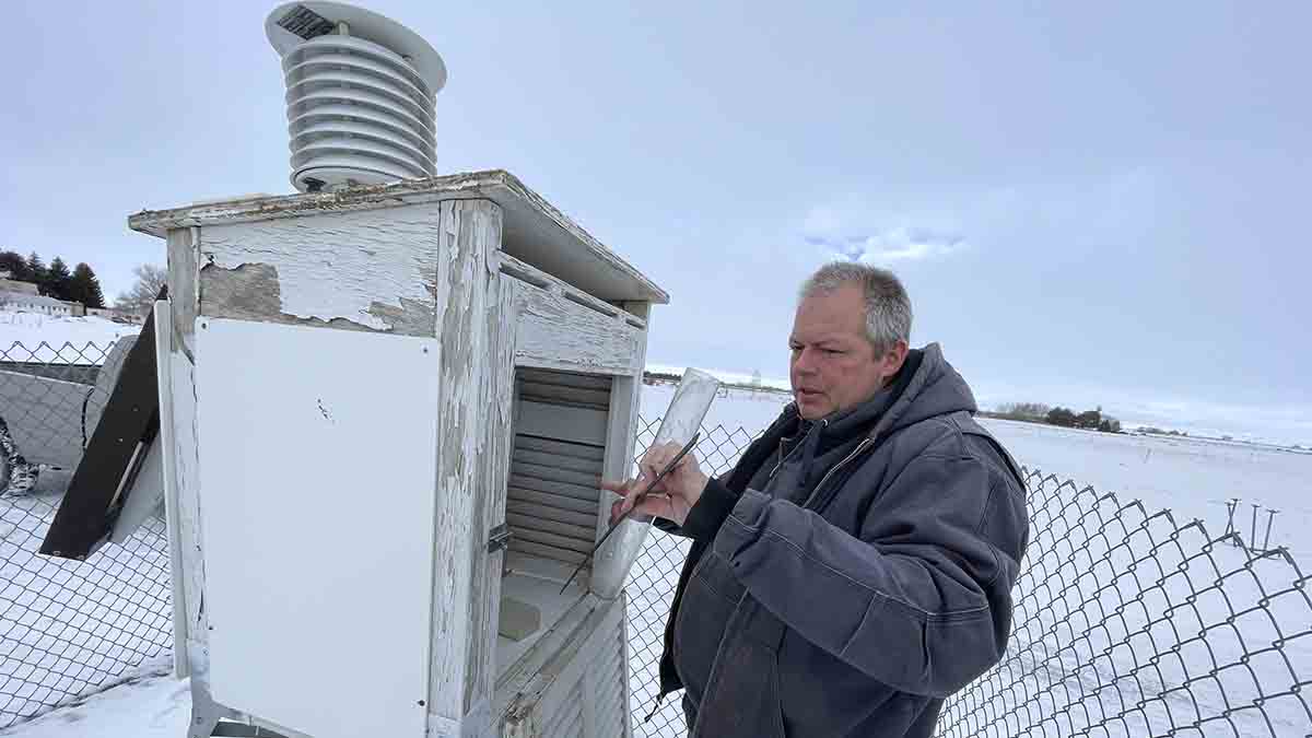 A man next to a weather station box.