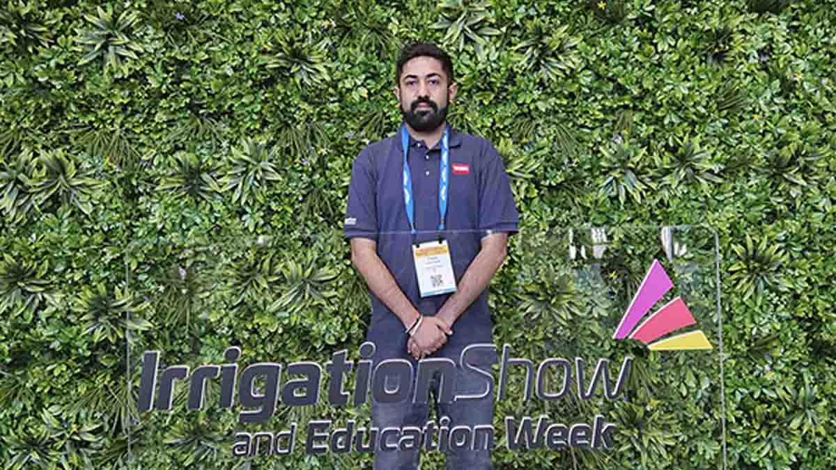 A man standing in front of a plant wall.