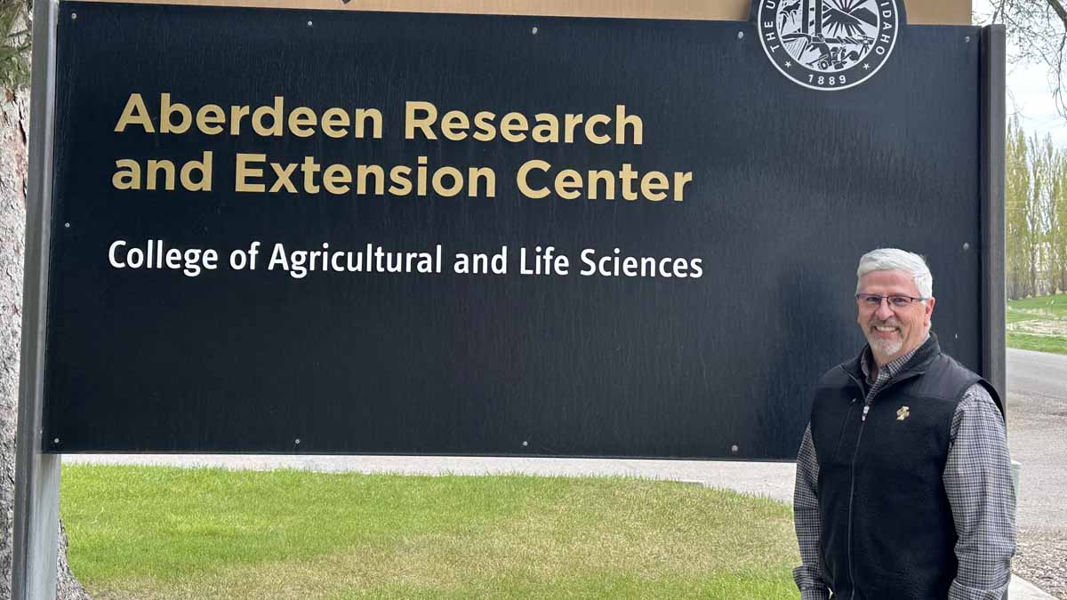 A man standing in front of a sign.