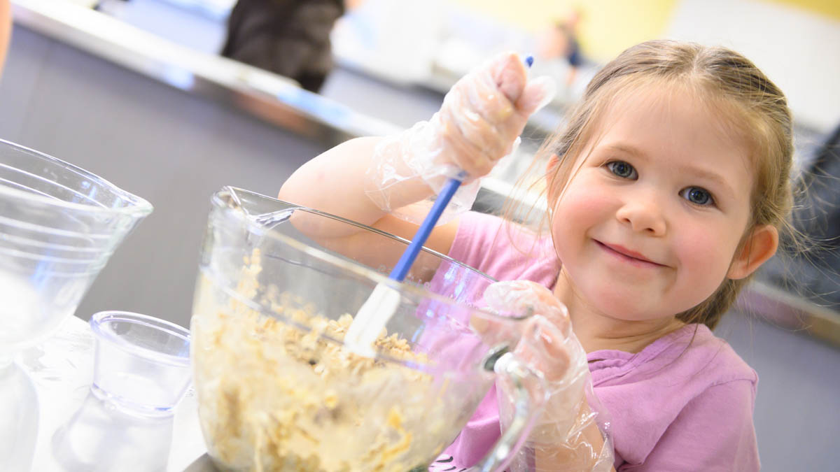 child with spatula in bowl