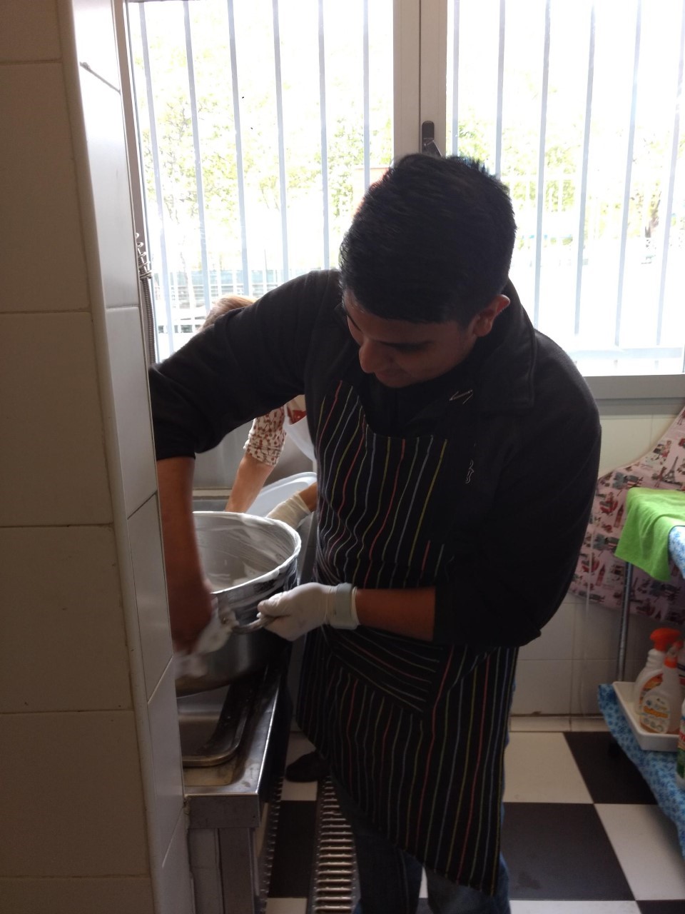 Ramon Juarez washes dishes in a soup kitchen in Madrid