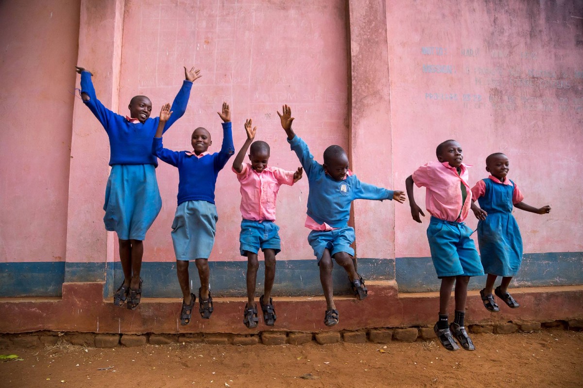 School girls in Africa jumping with their new shoes