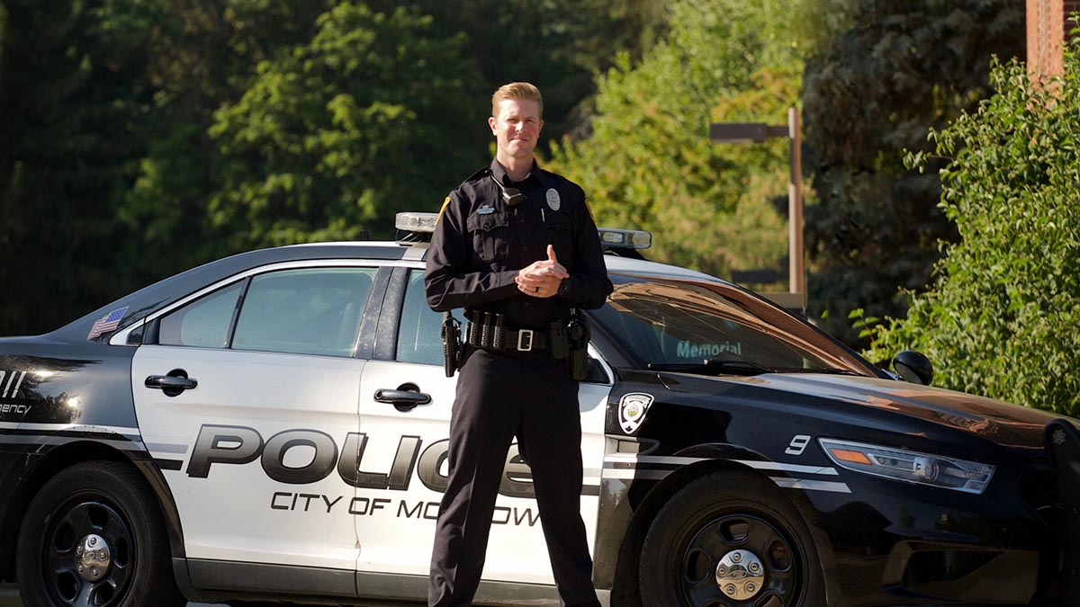 Jason House stands in front of a Moscow police car