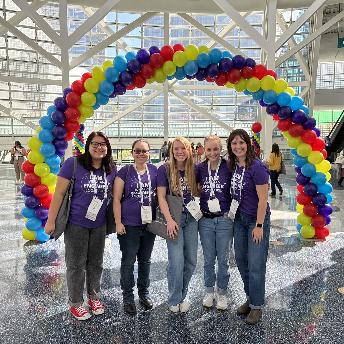 Five UI female engineers at a WIE conference.