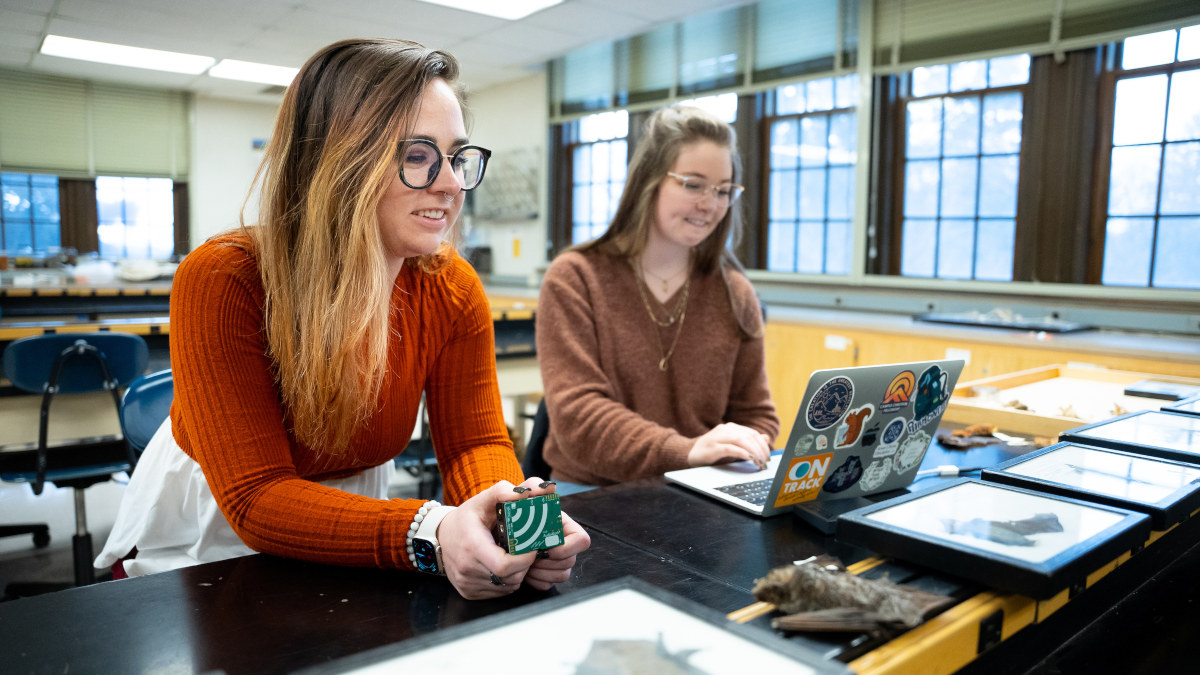 Two women at a lab desk talking