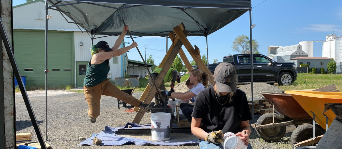 Photo of students under pop up tent making bricks