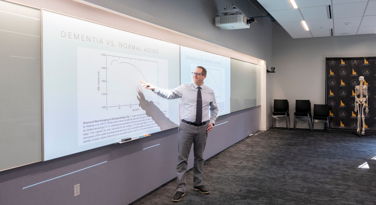 Professor lectures from a PowerPoint about dementia vs normal aging.