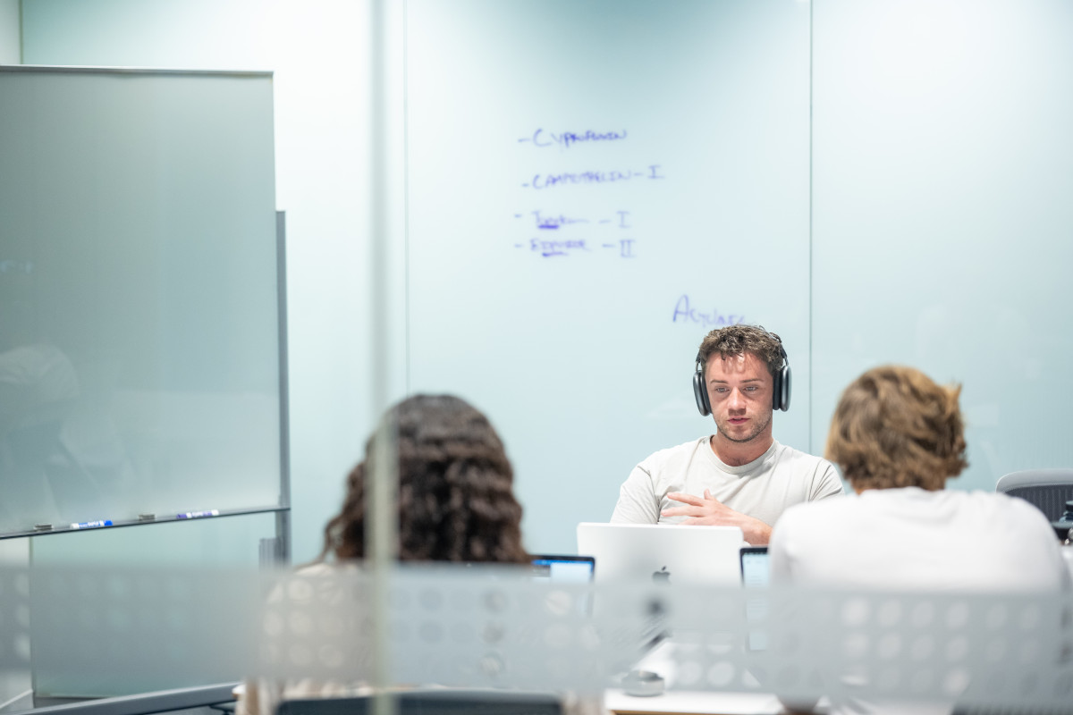 Three students work in a private study room together.