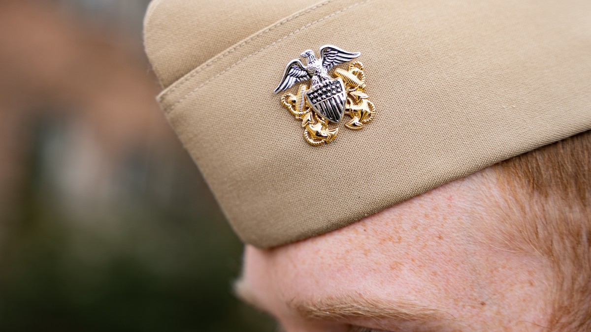 A Naval officer’s beige hat, decorated with an insignia with a silver eagle, starred-and-striped shield and gold anchors. 