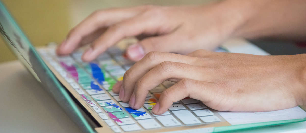 Hands typing on a computer