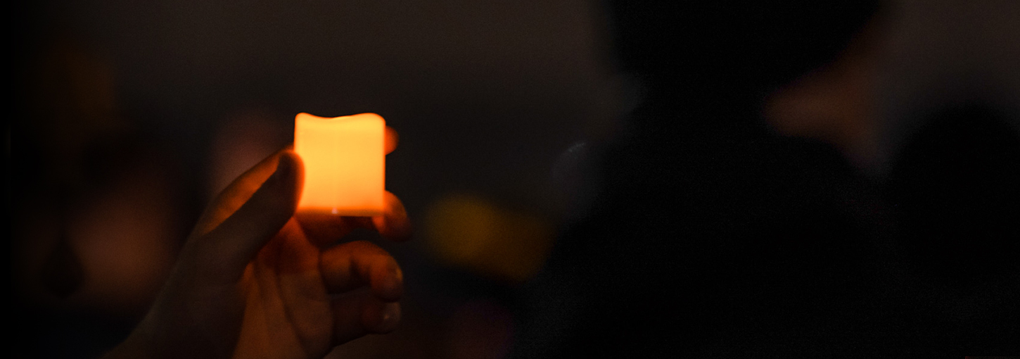 A student holds up a candle at the vigil for Ethan, Xana, Madison and Kaylee