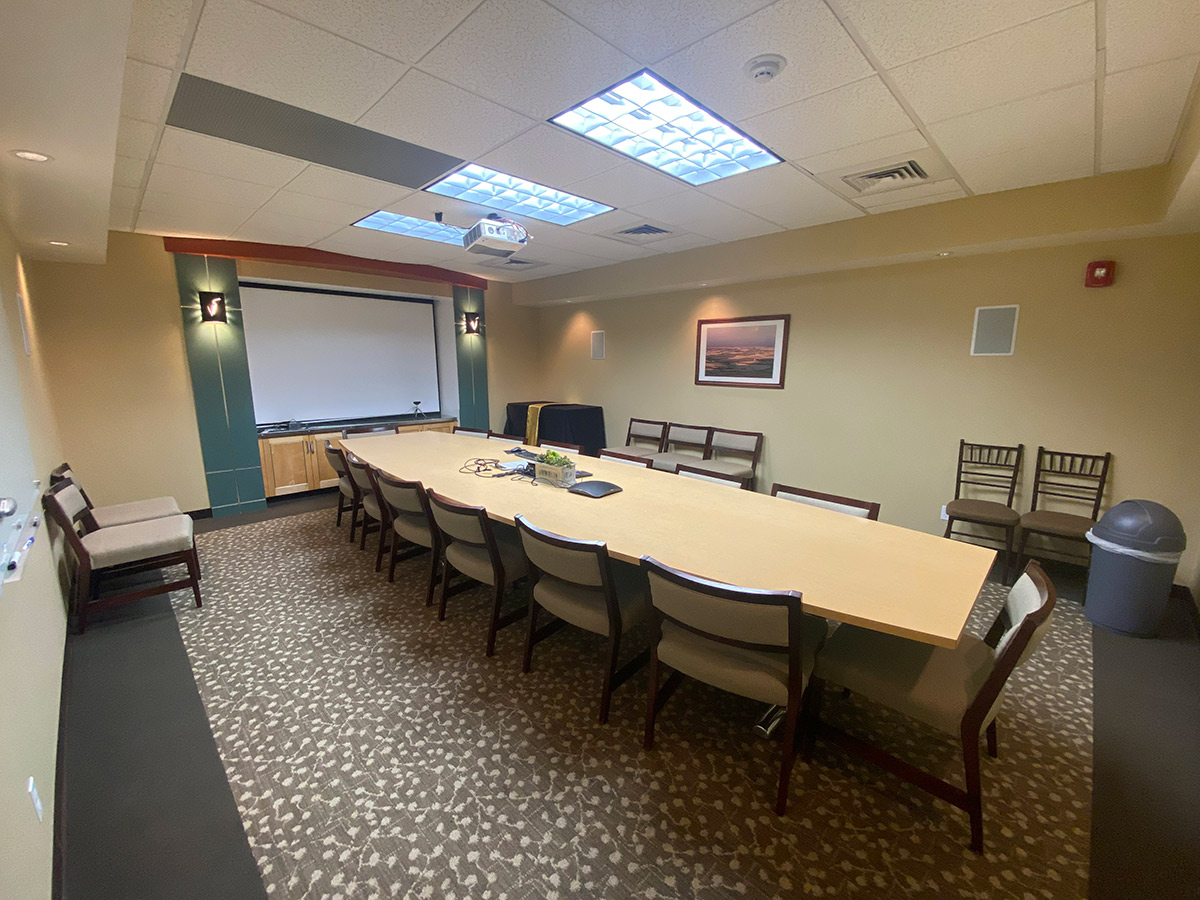 The whiteboard, conference room table and seats of the Morin Conference Room.