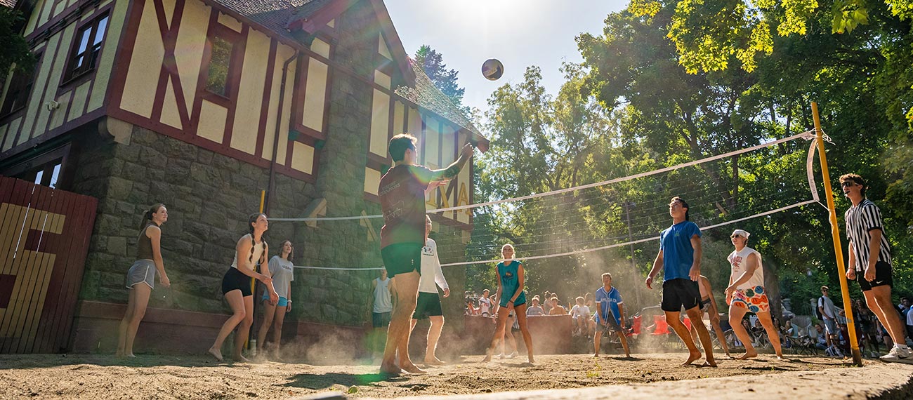 a group of students playing beach volleyball under the sun