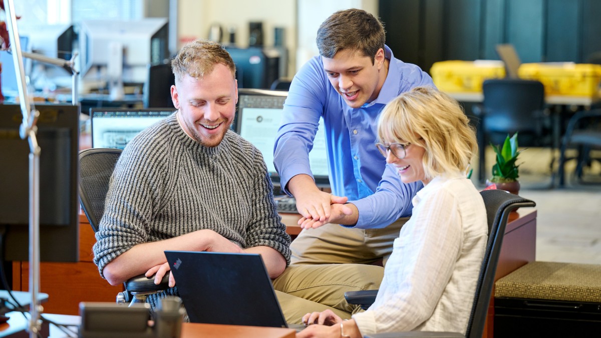 Tyler Schram working with other grad students at the IDL.