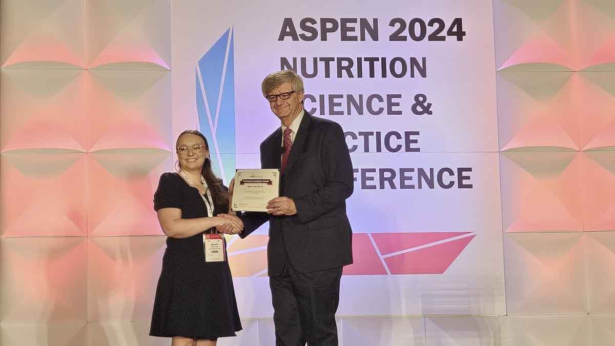 Megan Follett (left) receiving an award at the Aspen 2024 conference.