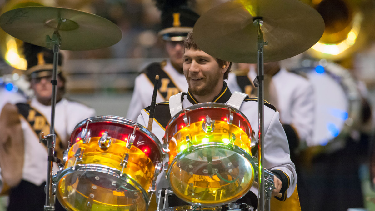 The drummer smiles behind the glowing drumset mounted atop the Beesten.