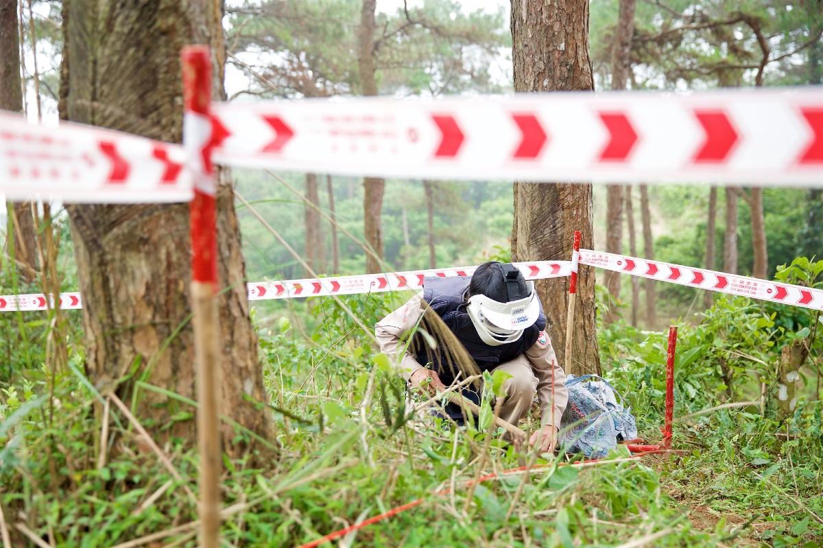 A miner behind a roped off area searching for bombs