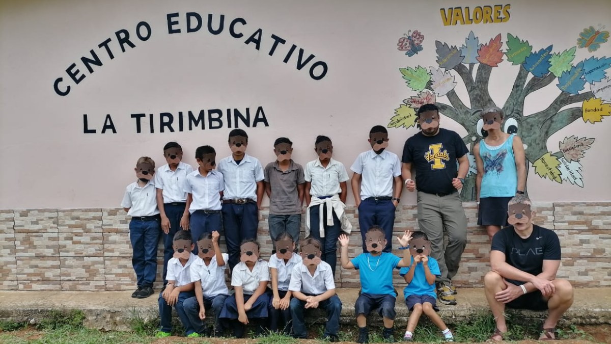 Santiago poses with a group of students wearing otter masks.