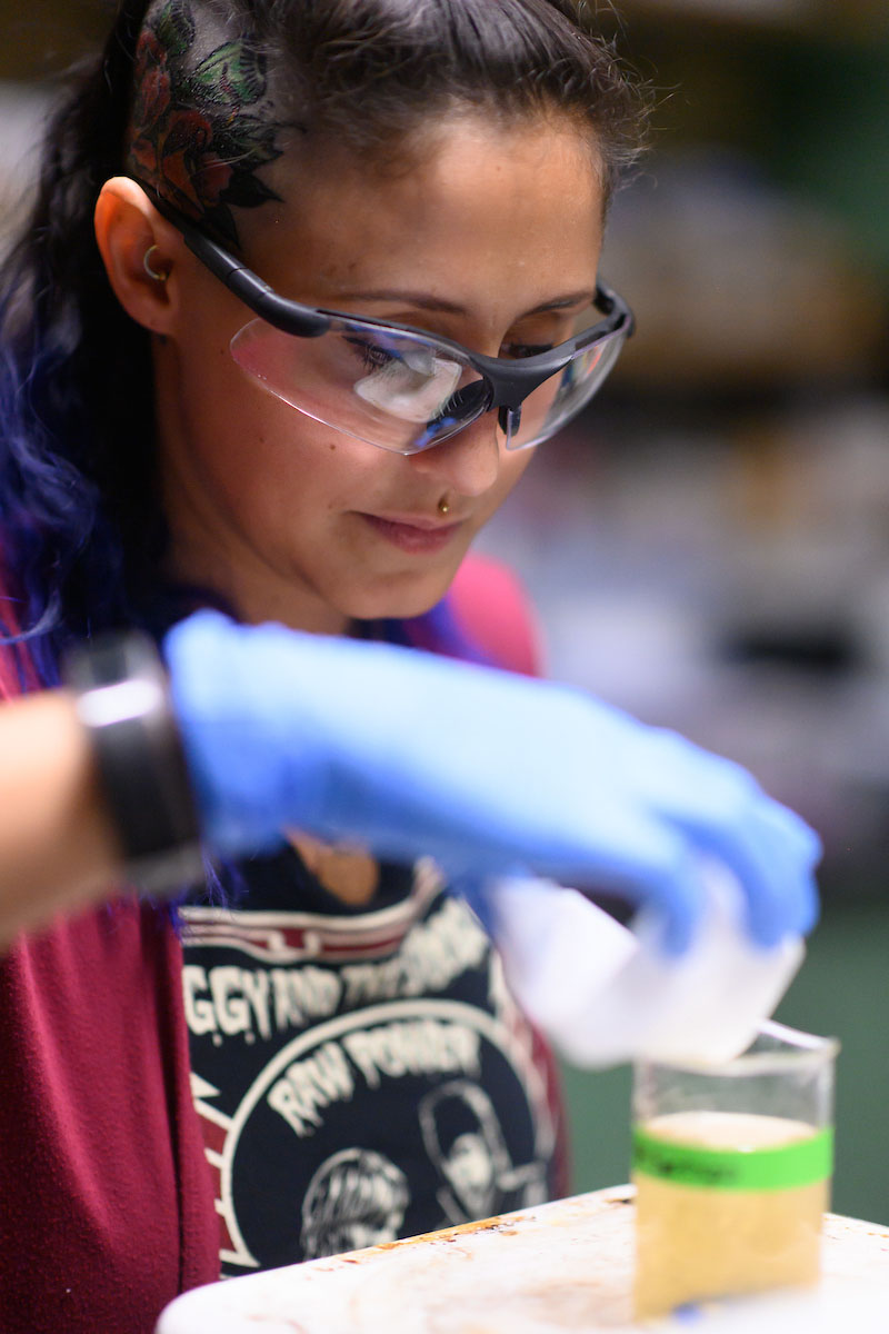 Alex Schlotterbeck works in a lab preparing liquids in a vile.