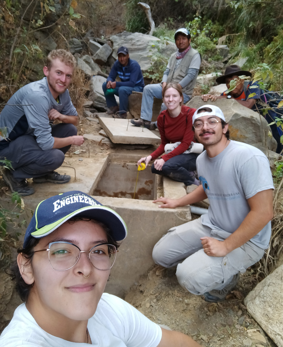 Students pose near a waterline access point