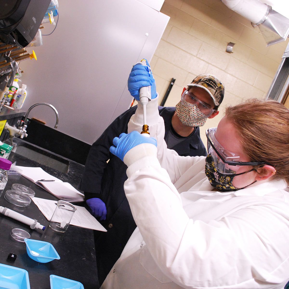 Chemical engineering seniors Travis Lindsay (left) and Roslyn McCormack refine four different polymer gels for research kits distributed to local elementary students.