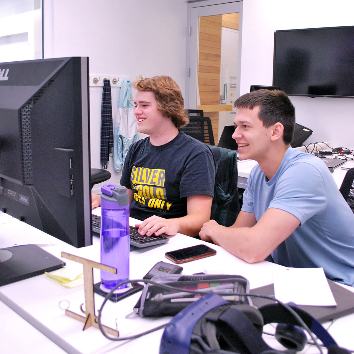 Two students at computers smiling