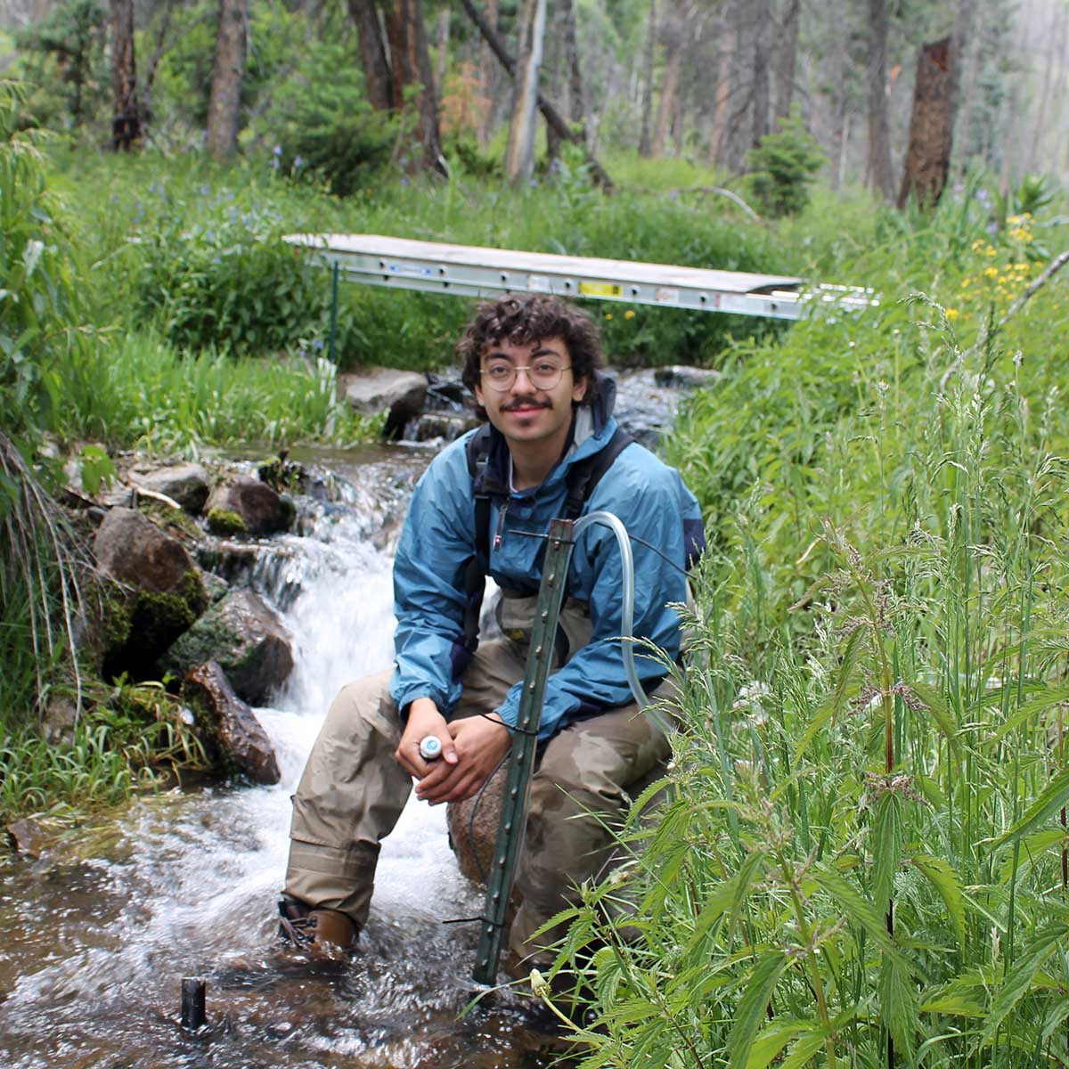 Korvin Jones, student in a forest with river