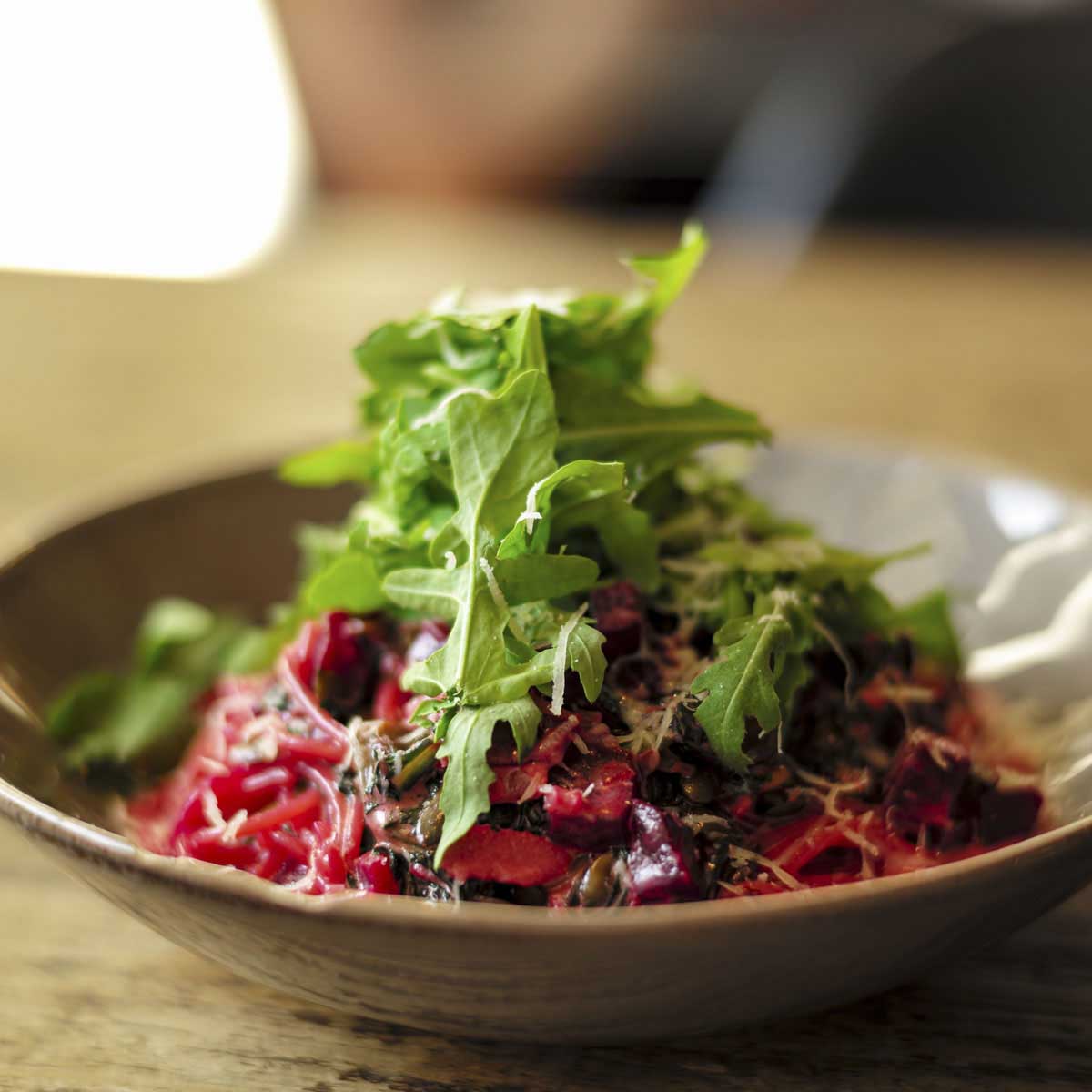 Arugula tops a red dish.