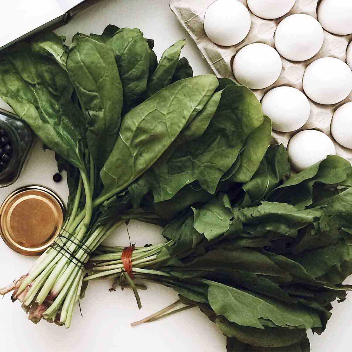 Sorrel leaves tied in a bundle on kitchen prep surface.